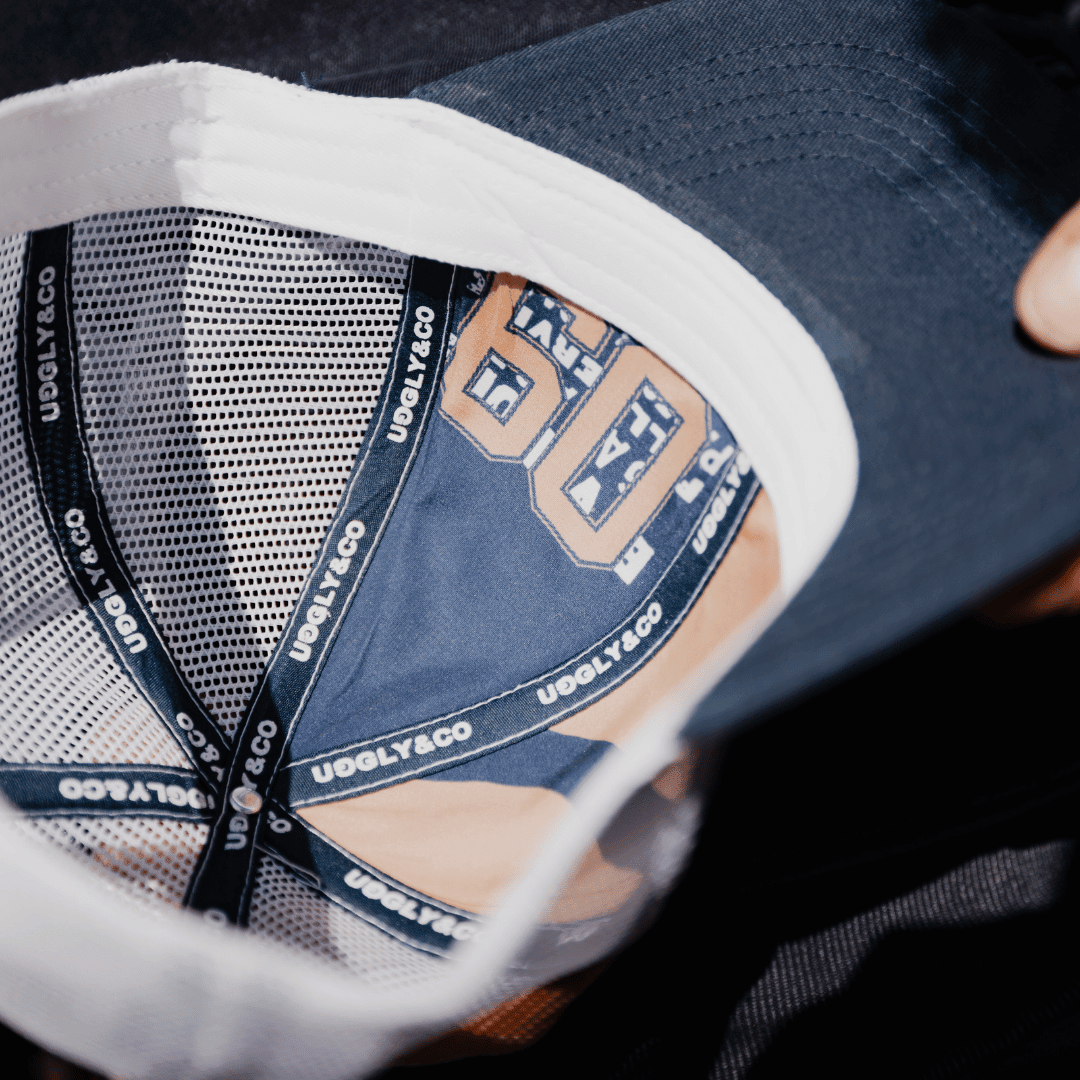 Navy trucker cap with "09" patch, Uggly and Co brand, featuring mesh back and adjustable snap closure.