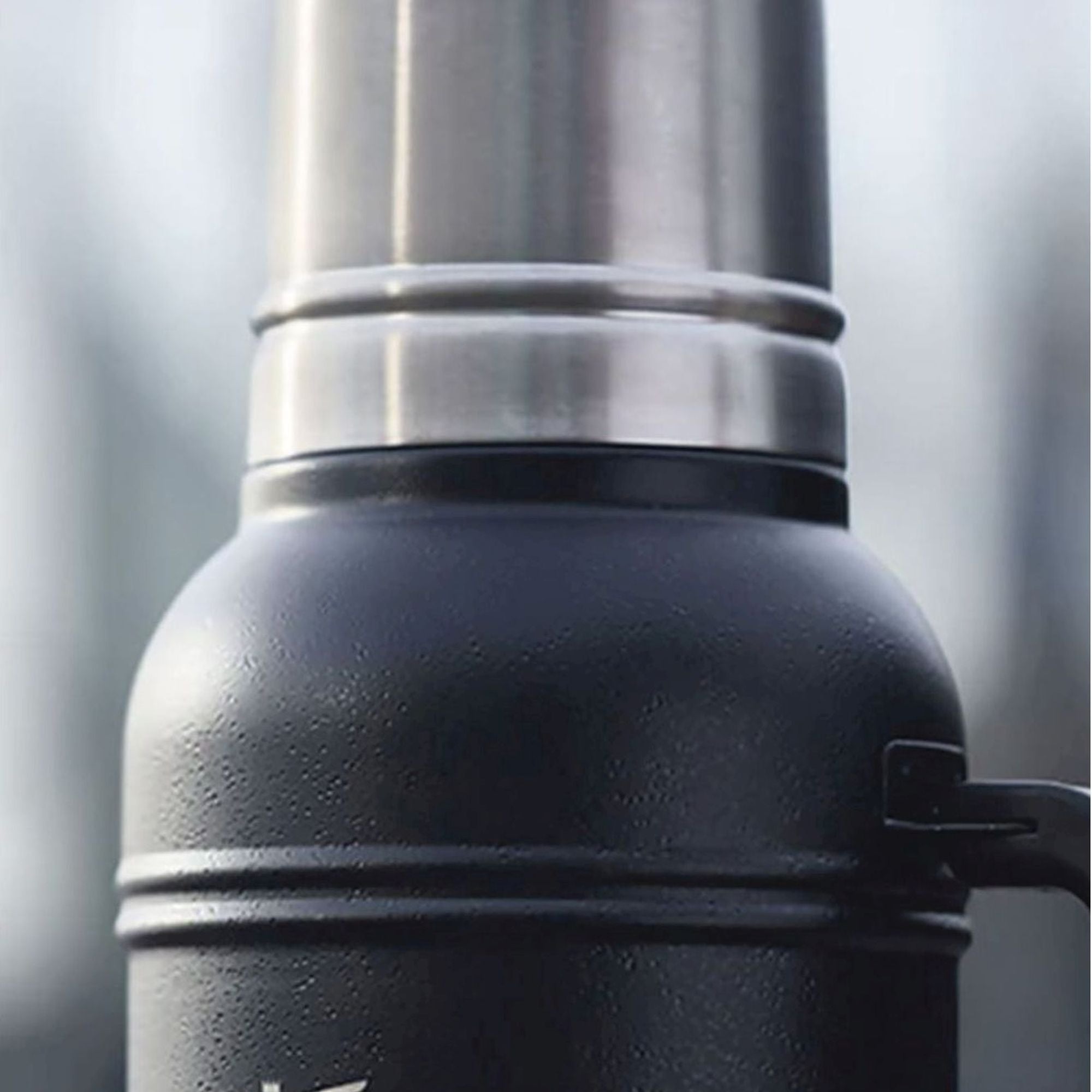 Stanley Artisan 1.4L thermal water bottle with stainless steel finish and leak-proof lid, designed for hot and cold beverages.