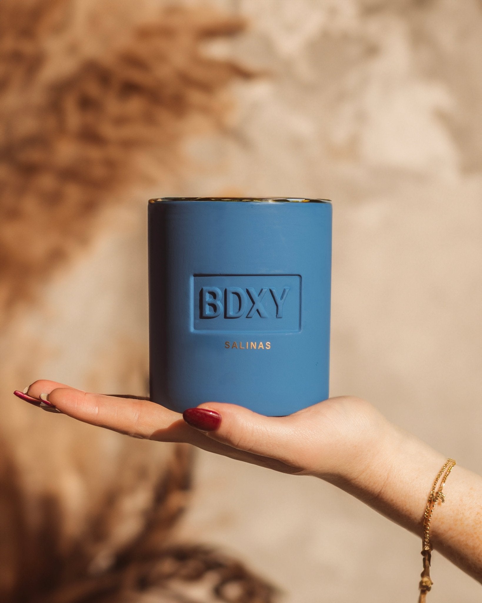 BDXY Studios scented candle from Salinas collection, featuring a sleek glass jar with a lit wick and fragrant floral scent.