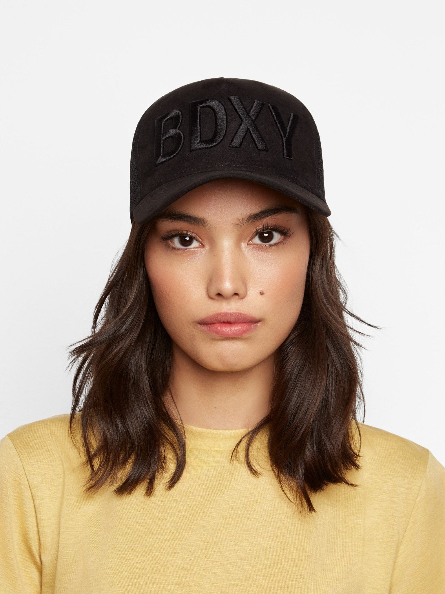 Black "The Gaffer" Trucker Cap by BDXY Studios featuring mesh back and curved brim, casual and adjustable for a stylish look.