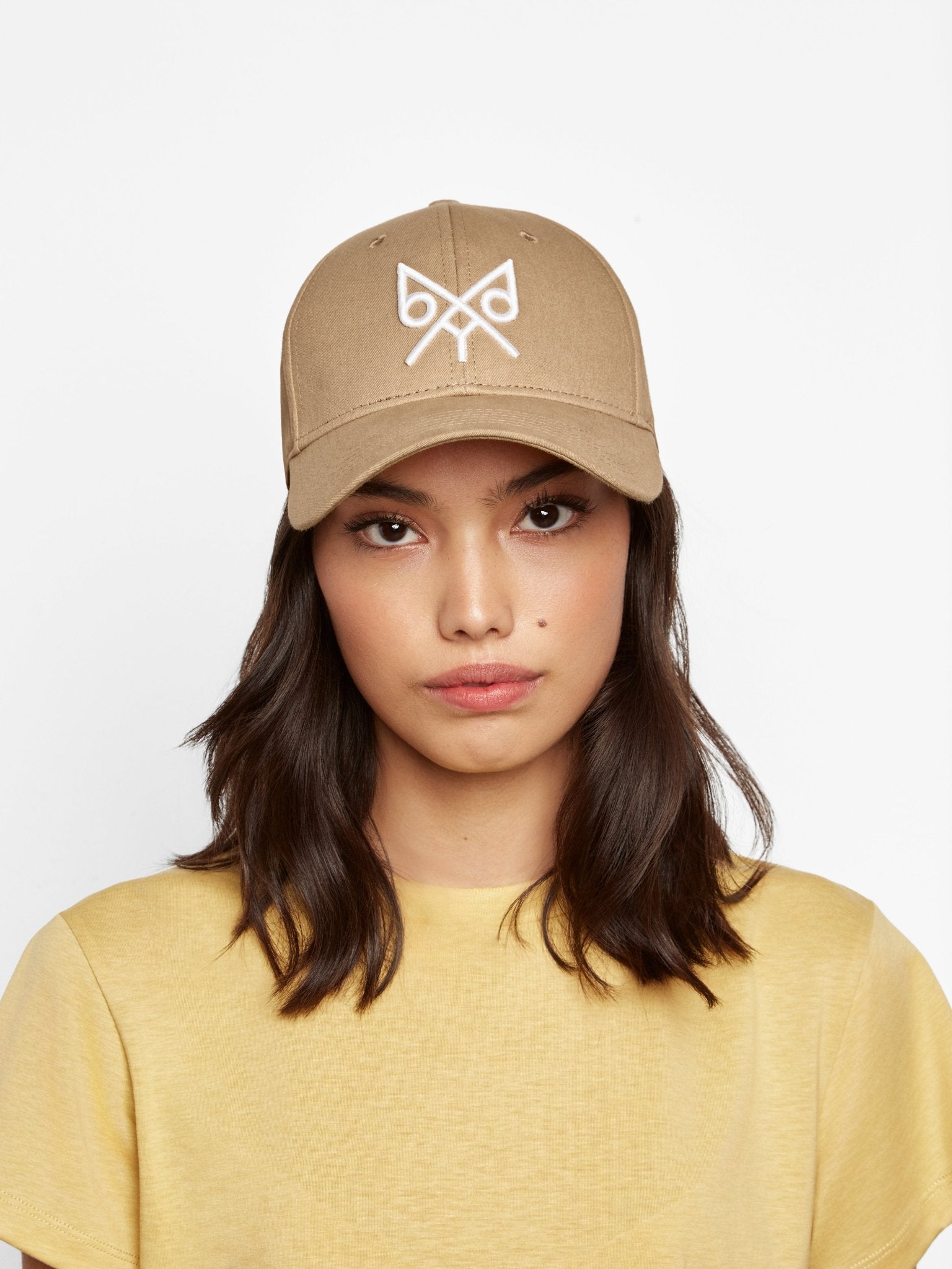 Tan baseball cap by BDXY Studios featuring "The Focus" design, casual cap with curved brim and adjustable strap.