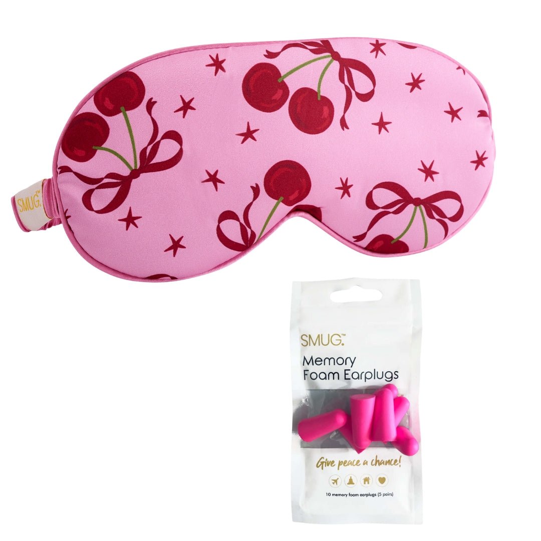 Pink satin sleep mask with cherry print by SMUG, soft and comfortable for restful sleep.
