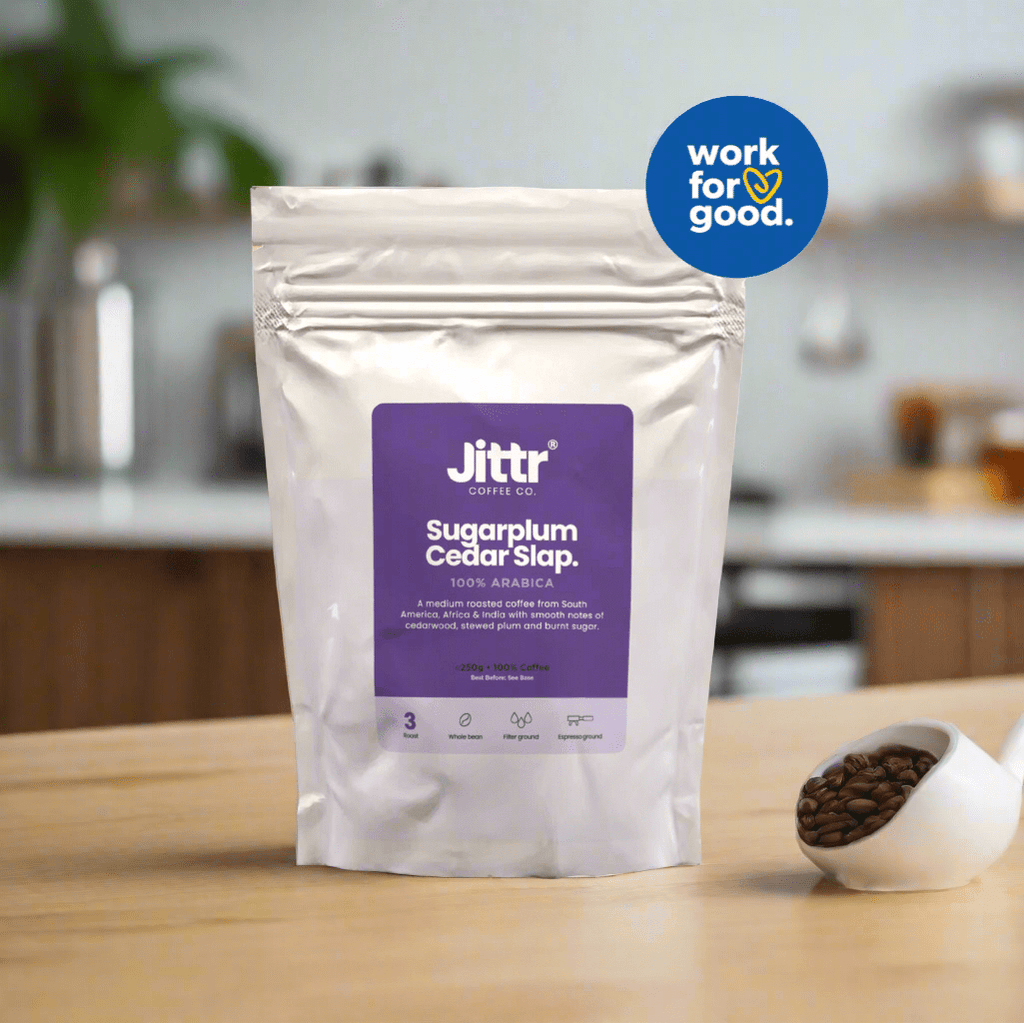 Jittr Coffee Co Sugarplum Cedar Slap coffee bag with label featuring a festive design and product details.