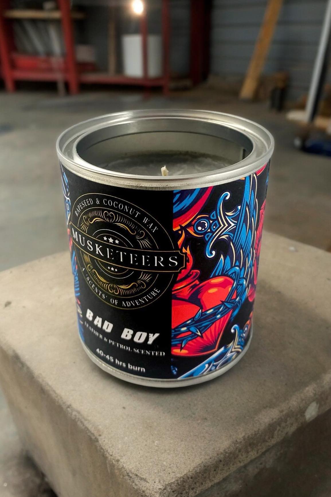 Musketeers Bad Boy Leather Candle with petrol and leather scent, masculine man cave candle, warm glow and leather packaging.