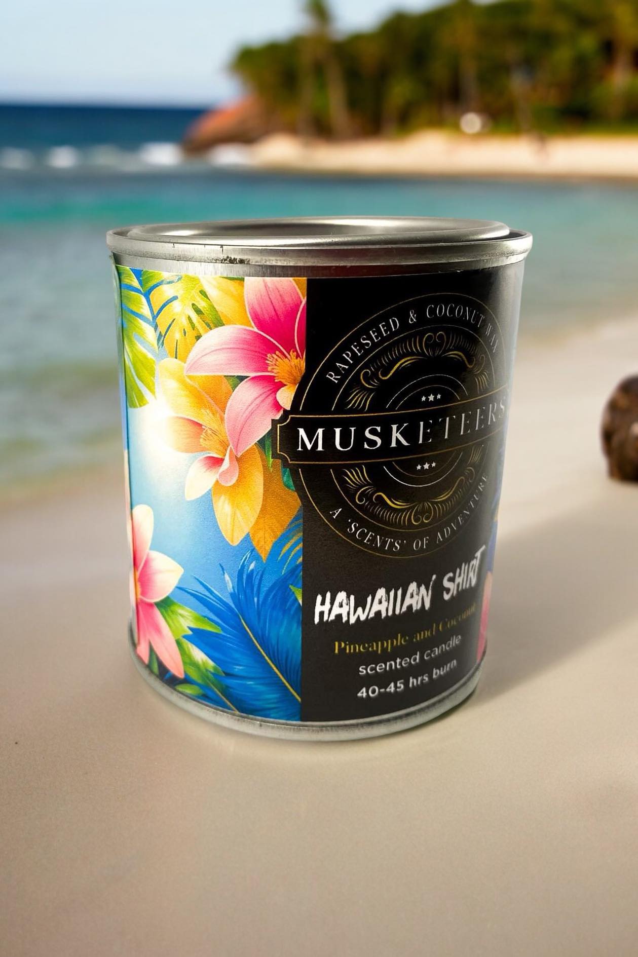 Musketeers Hawaiian candle with pineapple and coconut tropical scent, featuring a decorative candle in a vibrant design.