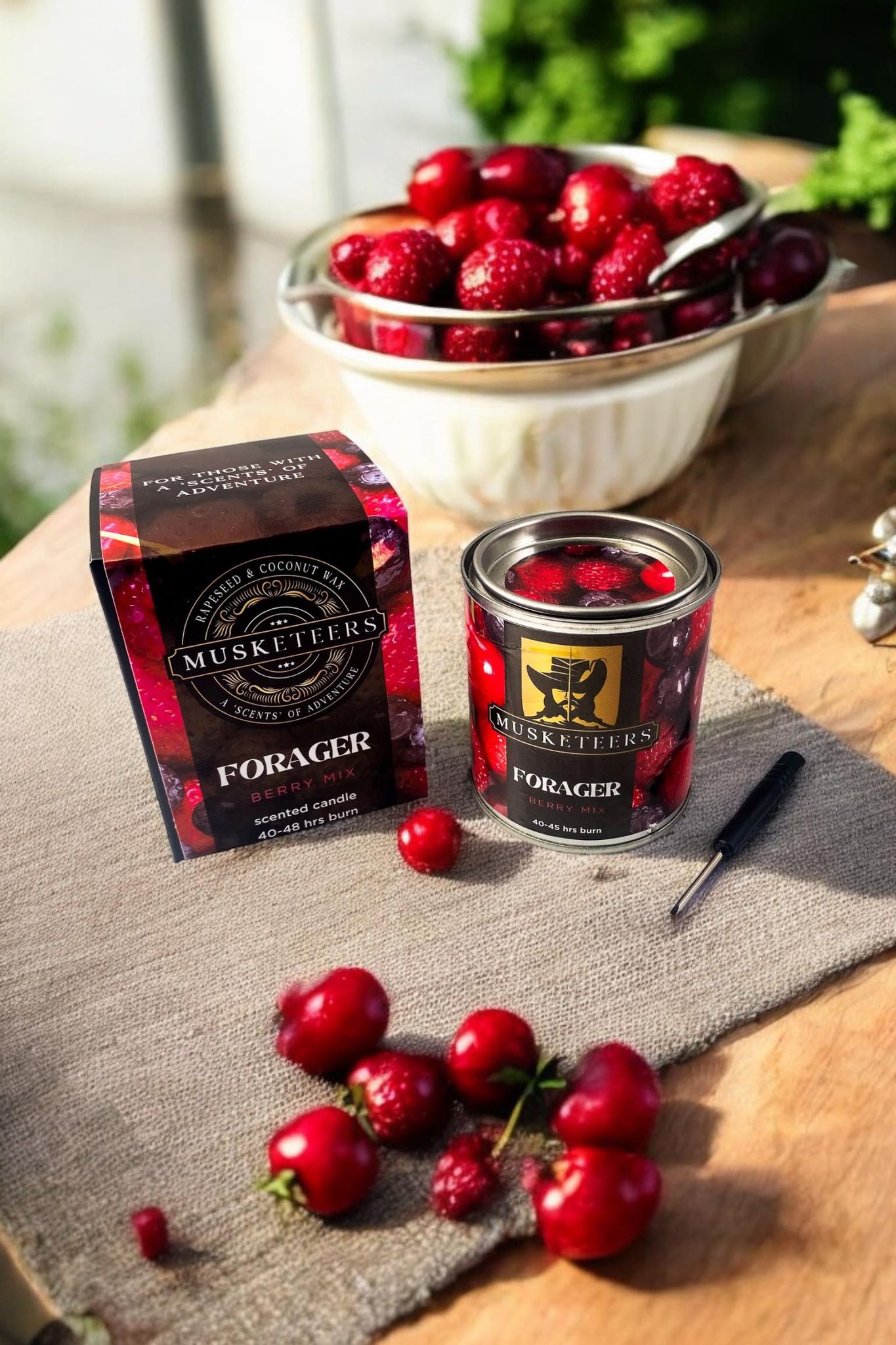 Musketeers Forager Berry Mix Candle with a glass jar and a lit wick, showcasing a fruity berry scent.