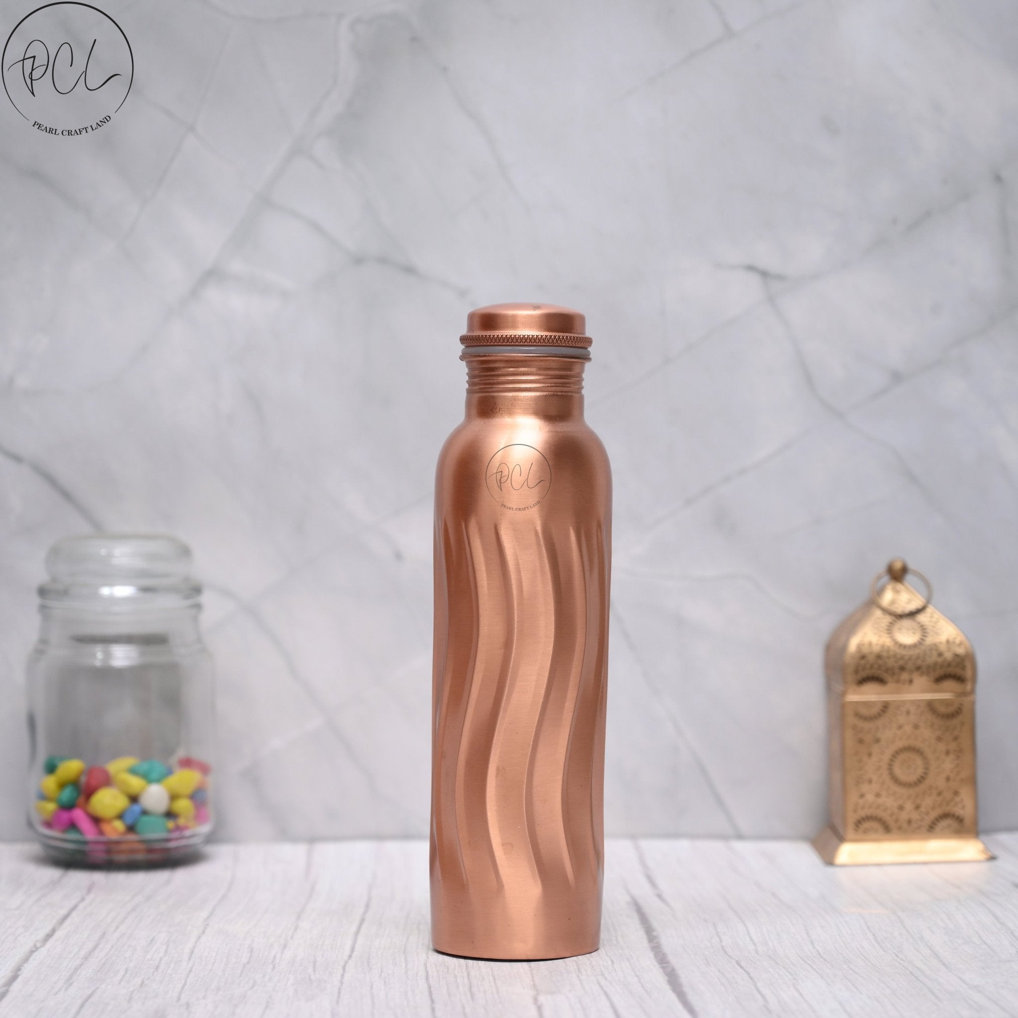 Unique wave design 100% pure copper water bottle from SAMA Homes, 950 ML capacity, with intricate wave pattern on the surface.