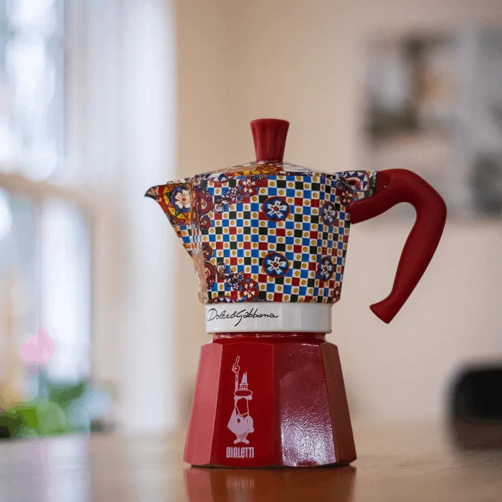 Bialetti Sicilian Cart Moka Express coffee maker with Dolce&Gabbana design, featuring a black and gold ceramic finish with intricate patterns.