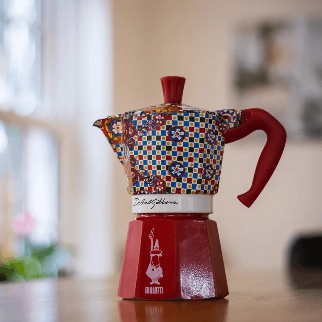 Bialetti Sicilian Cart Moka Express coffee maker with Dolce&Gabbana design, featuring a black and gold ceramic finish with intricate patterns.