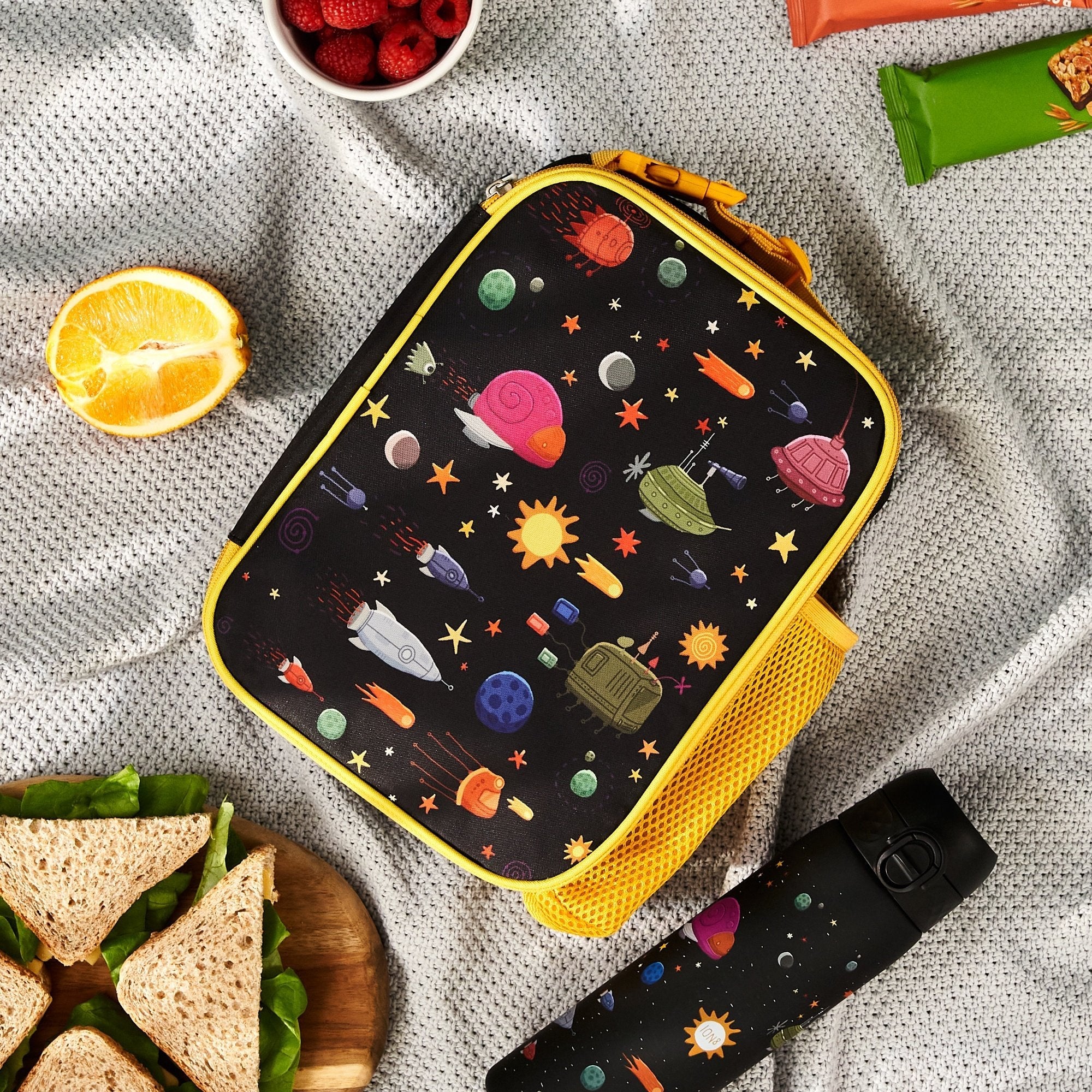 Insulated kids lunch bag with spaceship design from ION8, medium size, featuring a colorful space-themed pattern for children.