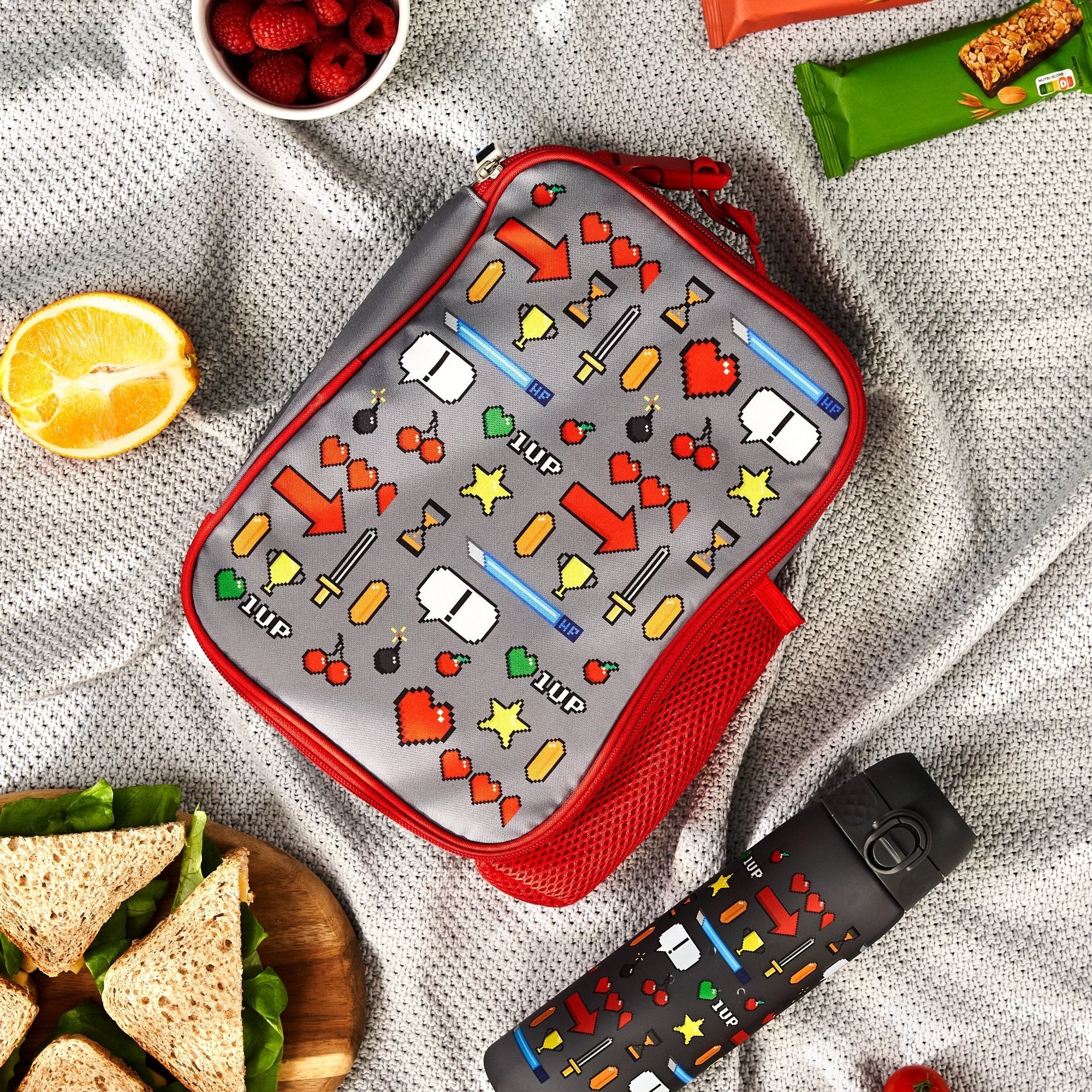 Kids insulated lunch bag by ION8 featuring a colorful gamer design, medium size with insulated interior for snacks and drinks.