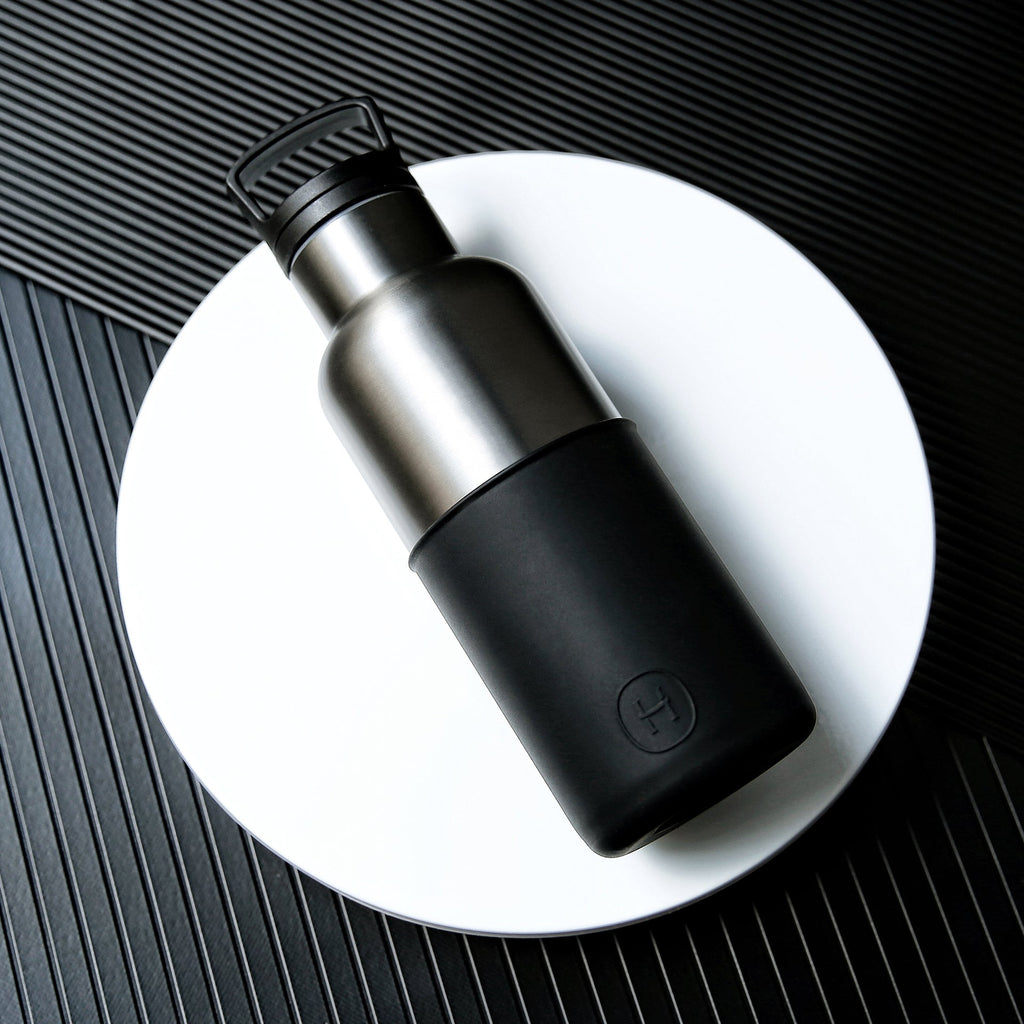 Titanium grey and ink black HYDY 16 oz bottle with black cap, made of durable plastic, for beverages or storage.