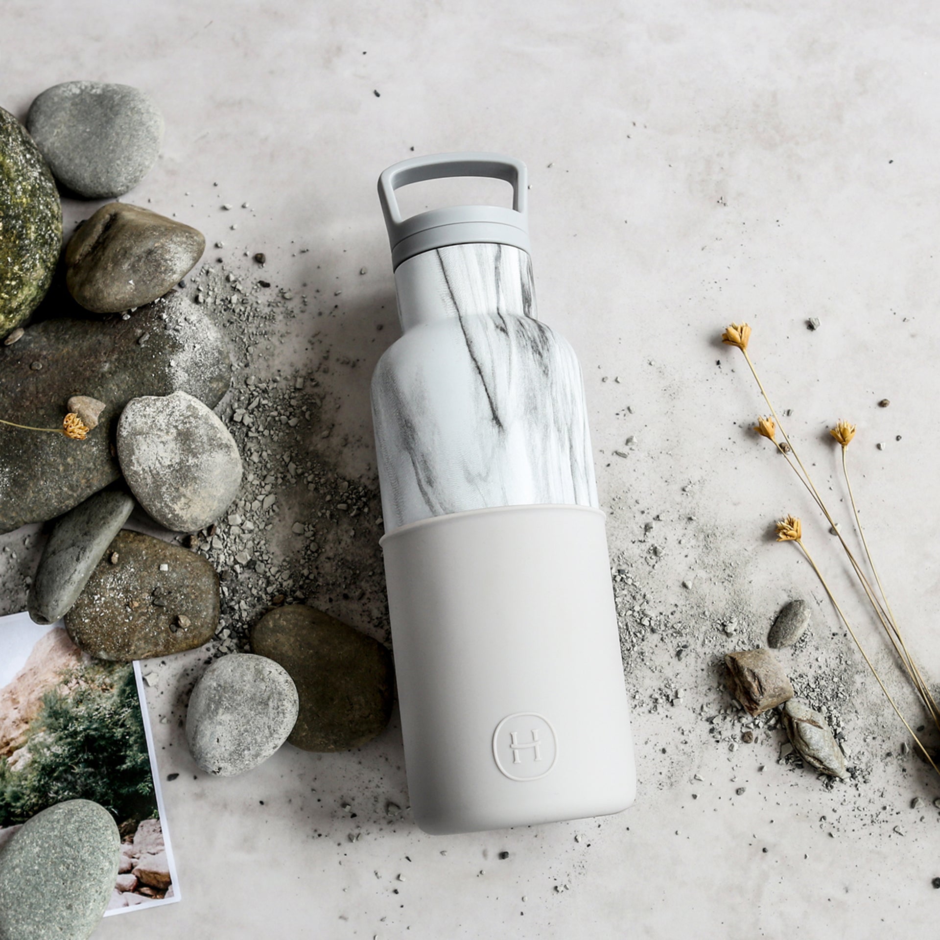 White marble and cloudy grey 16 oz HYDY glass bottle with a sleek, modern design and durable construction.