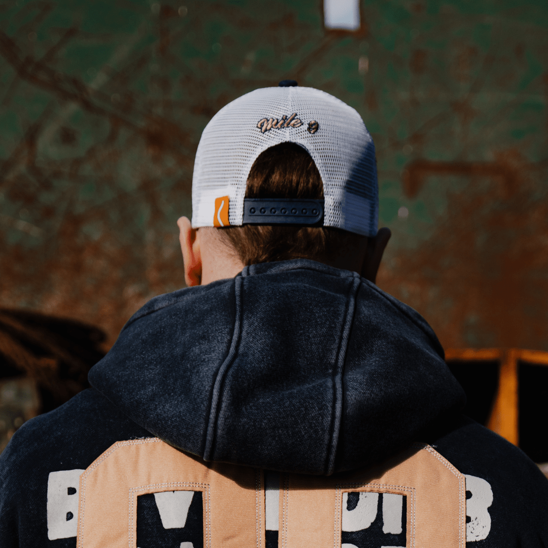 Navy Uggly and Co trucker cap with '09' print, casual biker-style hat with mesh back and adjustable strap.