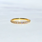 Gold ring with small diamonds on a light gray background