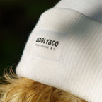 Close-up of white Uggly and Co beanie with visible logo detail, showing soft knit fabric and snug fit.