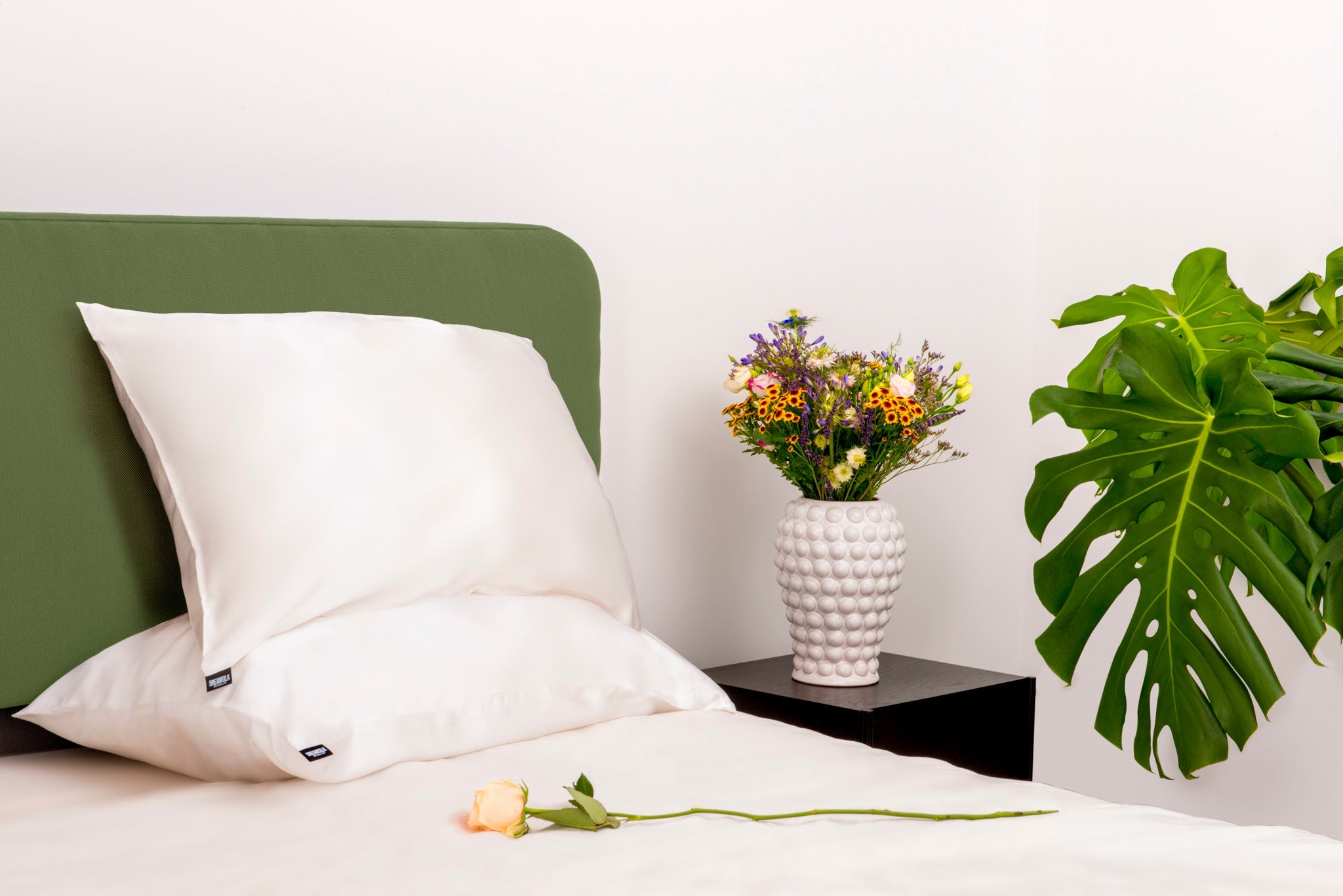 DreamSilk luxury silk pillowcase with smooth, shiny fabric and a soft, elegant appearance on a bed.
