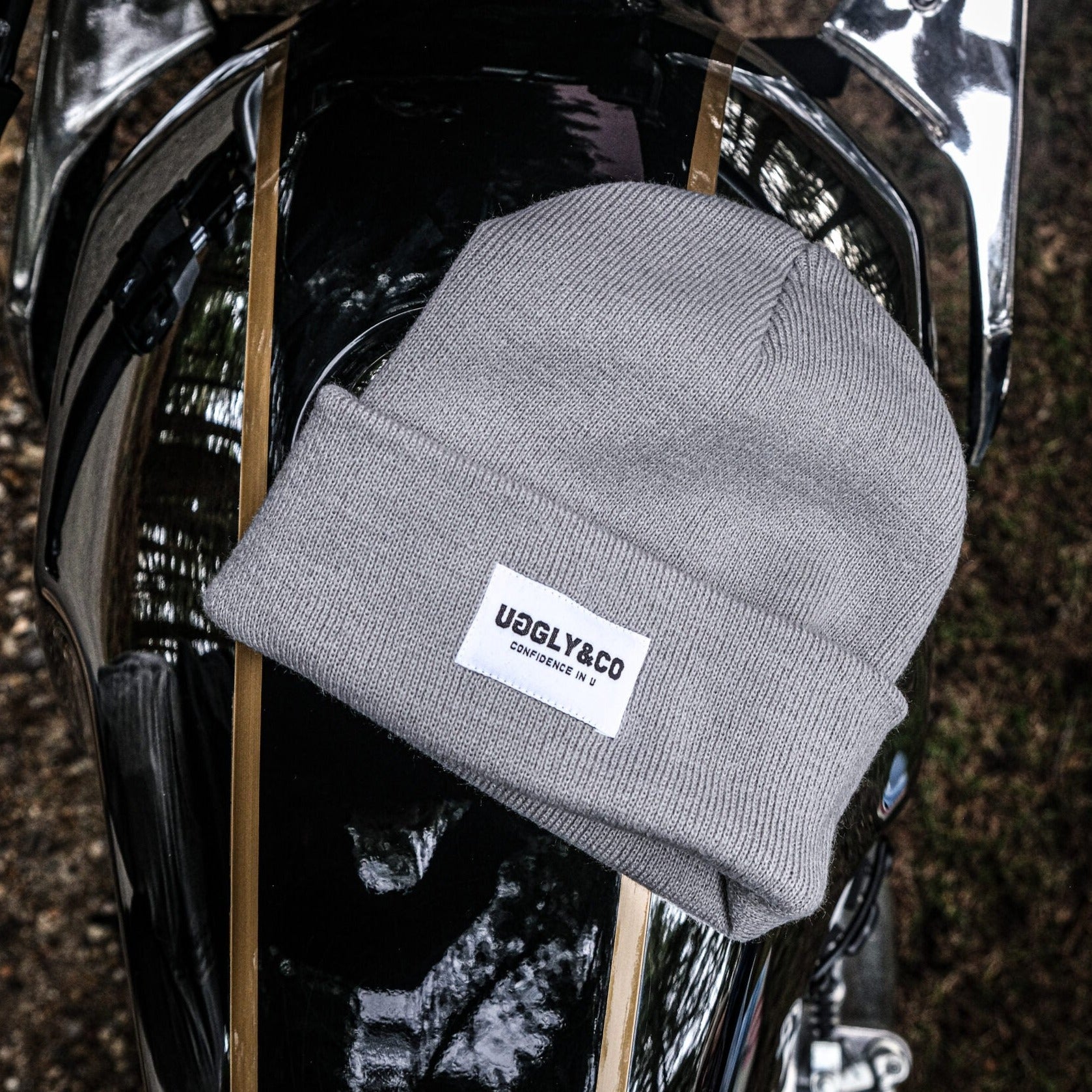 Grey Uggly and Co beanie hat with a soft knit texture, shown on a model's head for a cozy winter look.