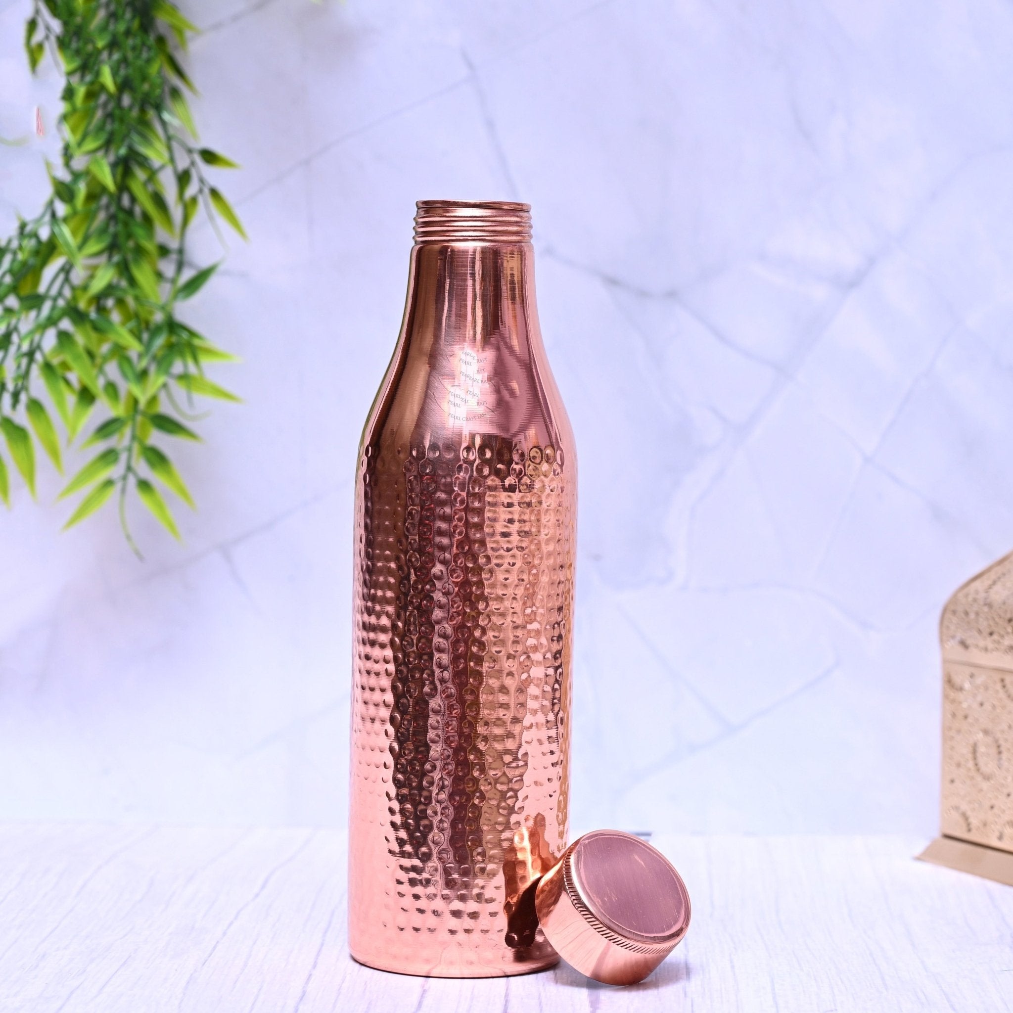 Pure copper water bottle with hammered design, 1000ml capacity, by SAMA Homes, featuring a sleek, plain finish.
