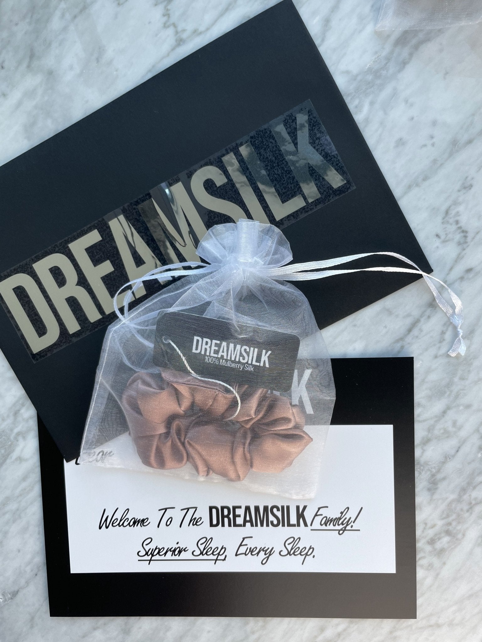 Bronze silk scrunchie by DREAMSILK, regular size, soft and shiny silk fabric, shown coiled with smooth, lustrous appearance.
