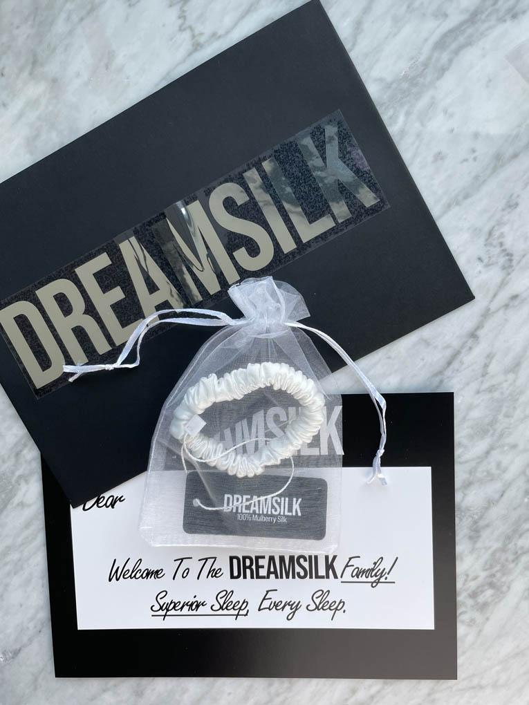 White silk scrunchie by DREAMSILK, skinny style, made from smooth, shiny silk fabric perfect for hair accessories.
