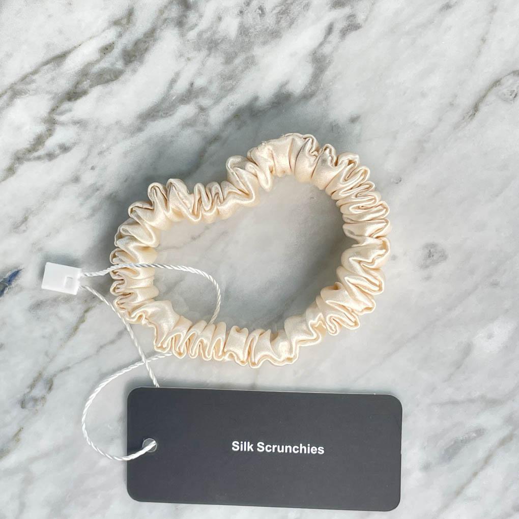 DREAMSILK champagne silk scrunchie, skinny style, made of smooth silk fabric, shown on a white background.