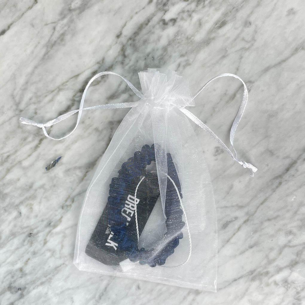 Navy blue silk skinny scrunchie by DREAMSILK, smooth and shiny hair accessory shown on a white background.