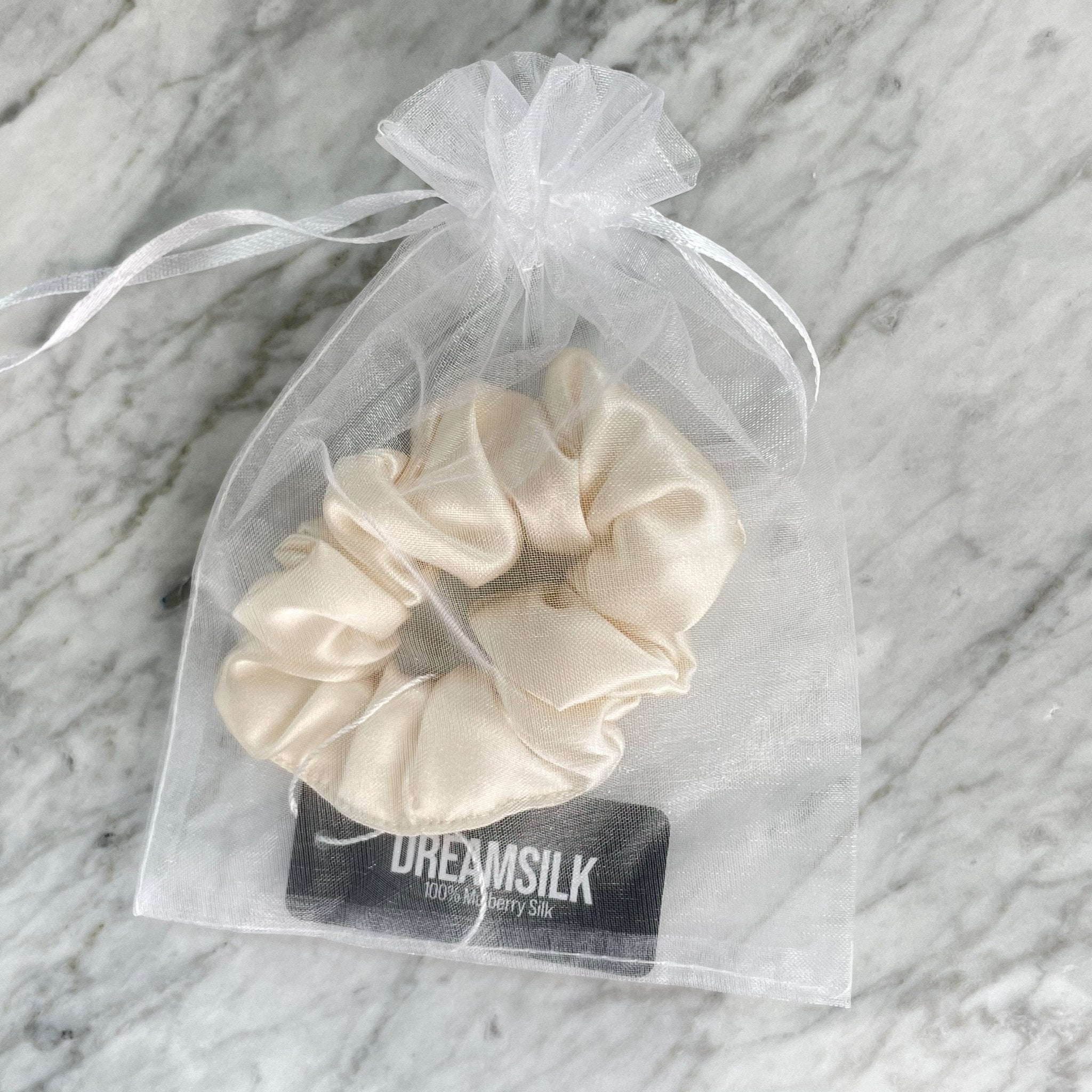 DREAMSILK Champagne silk scrunchie, regular size, made of smooth, shiny silk fabric for gentle hair styling.
