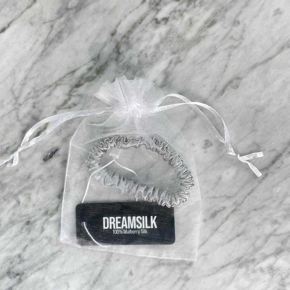 Silver silk scrunchie from DREAMSILK, a skinny hair accessory made of smooth, shiny silk fabric.