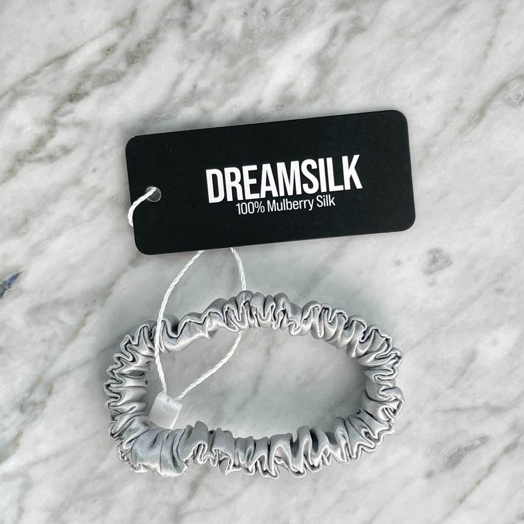 Silver silk scrunchie by DREAMSILK, skinny silk hair tie with smooth, shiny fabric for gentle hold and elegant style.