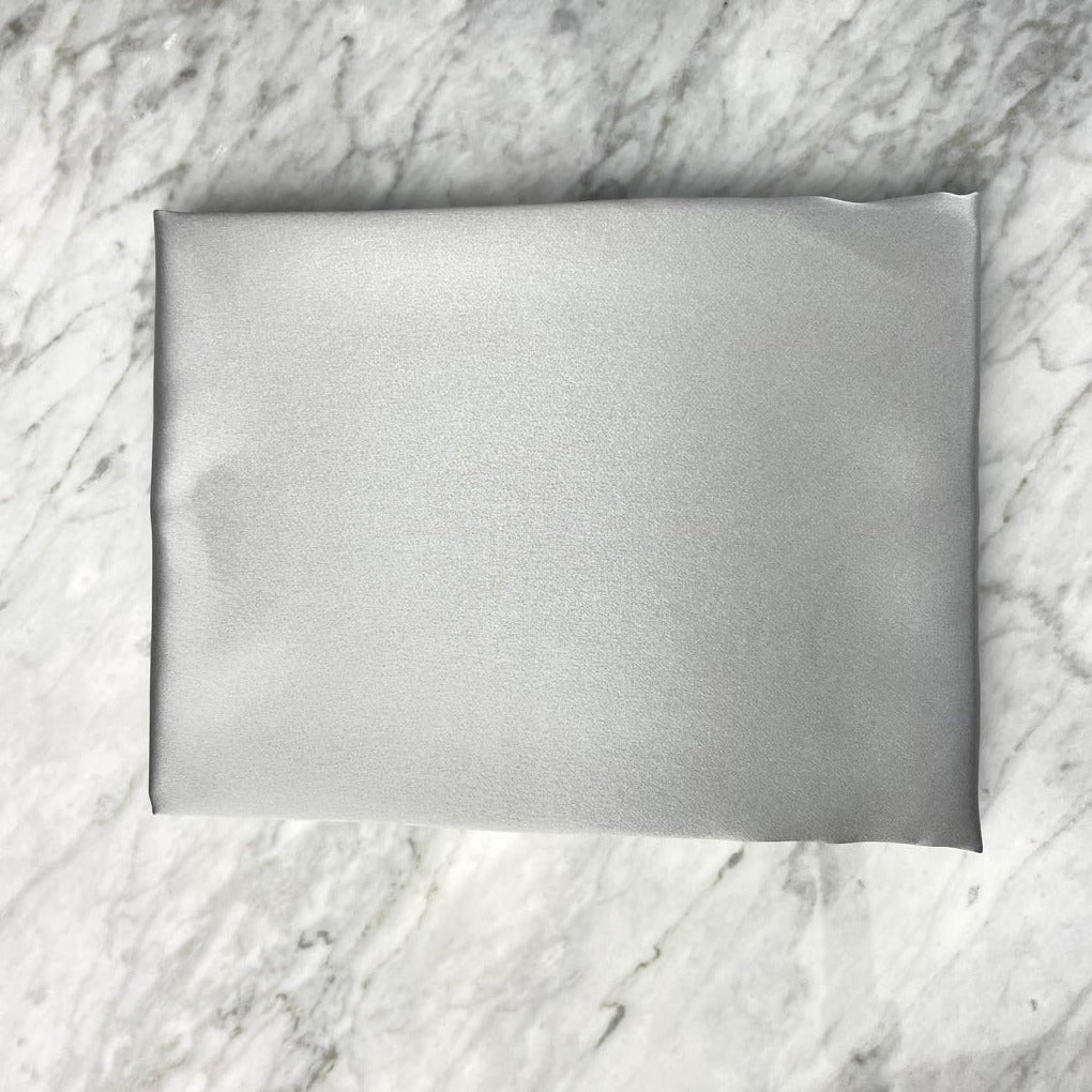 Silvery silk pillowcase from DREAMSILK in standard size, showcasing smooth, shiny silk fabric with a soft, luxurious appearance.