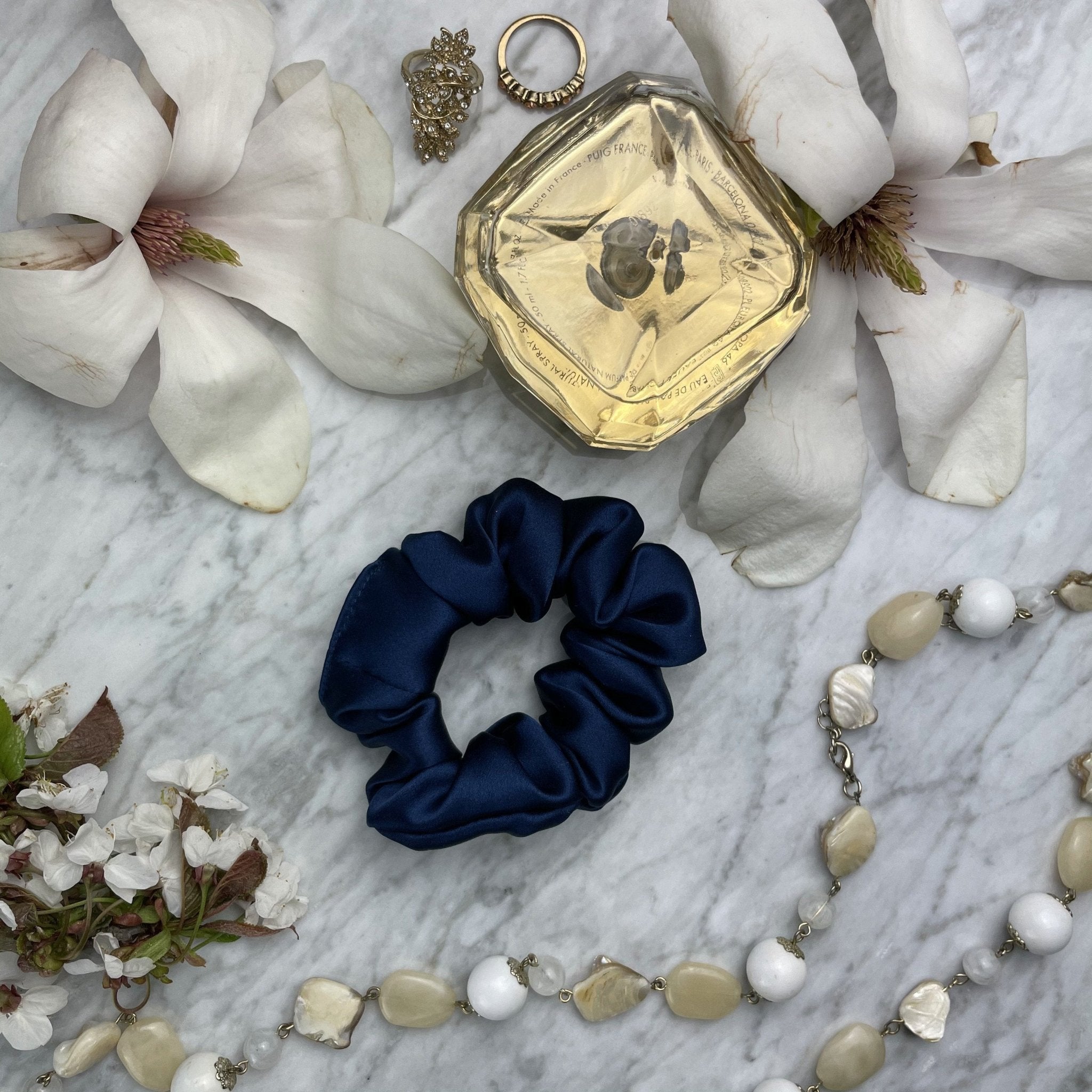 Navy blue silk scrunchie from DREAMSILK with a soft, smooth fabric for gentle hair holding and stylish accessory.