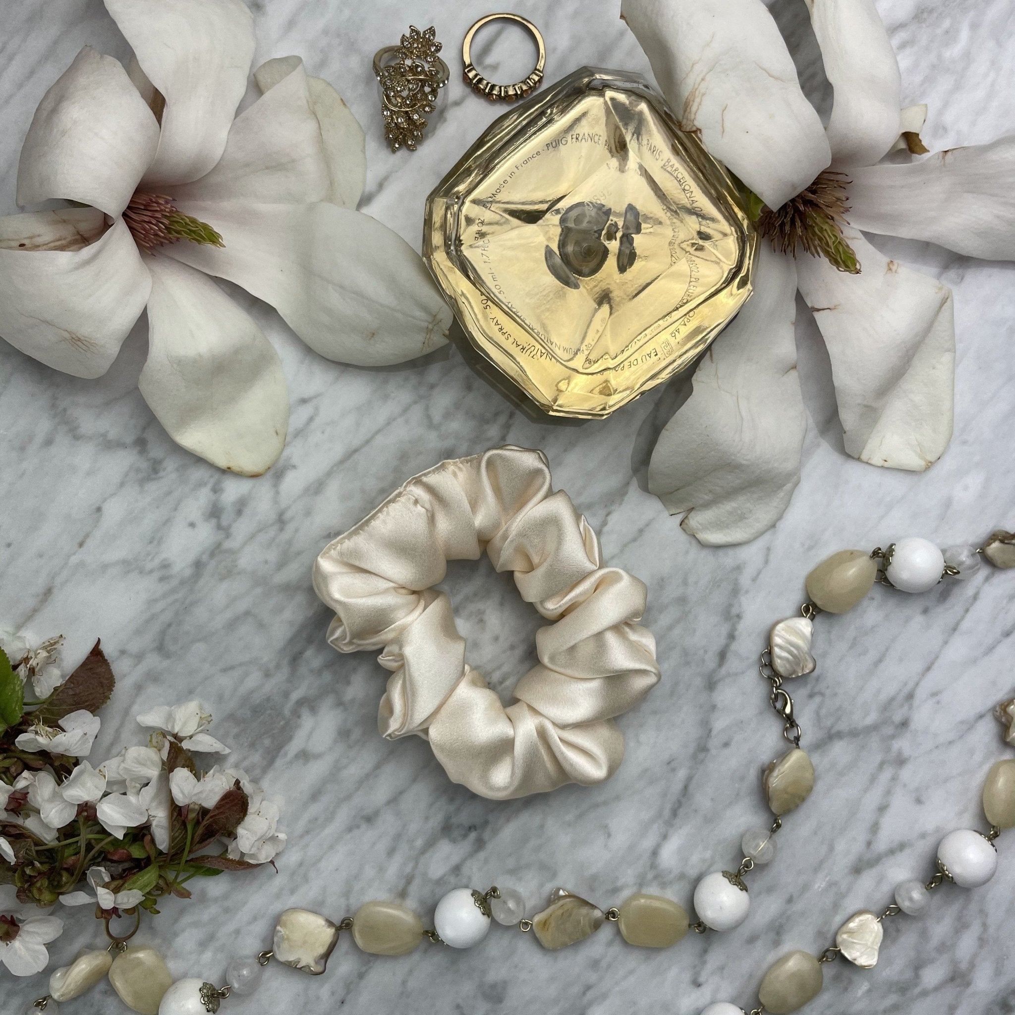 DREAMSILK Champagne silk scrunchie on a hair strand, showcasing its smooth, shiny fabric and elegant design.