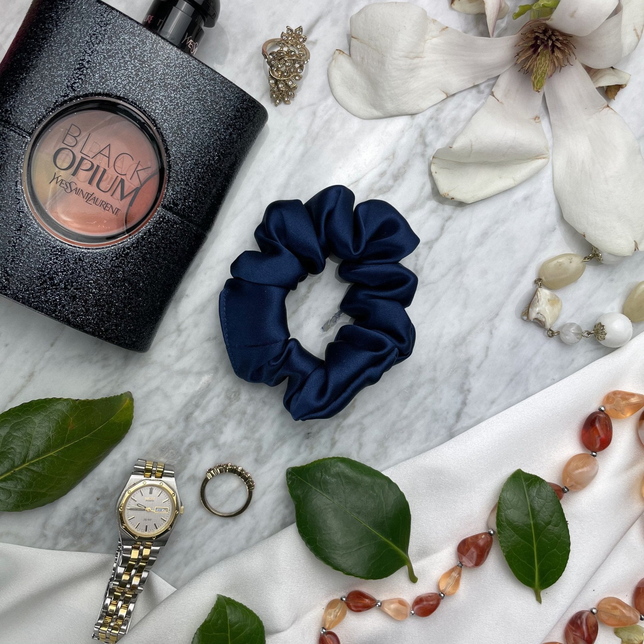 Navy blue silk scrunchie from DREAMSILK with a smooth, shiny texture, designed for gentle hair hold.