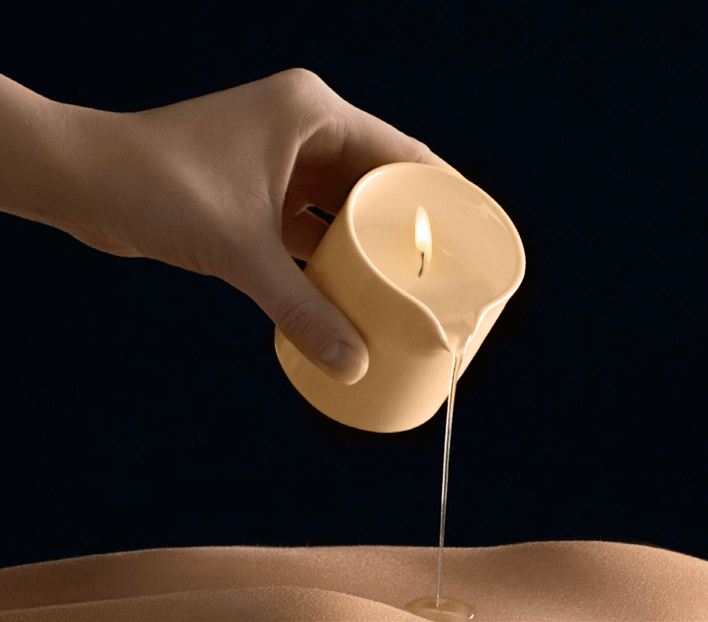 Scented massage candle by Musketeers with mandarin and sandalwood, melting to create warm, aromatic massage oil.