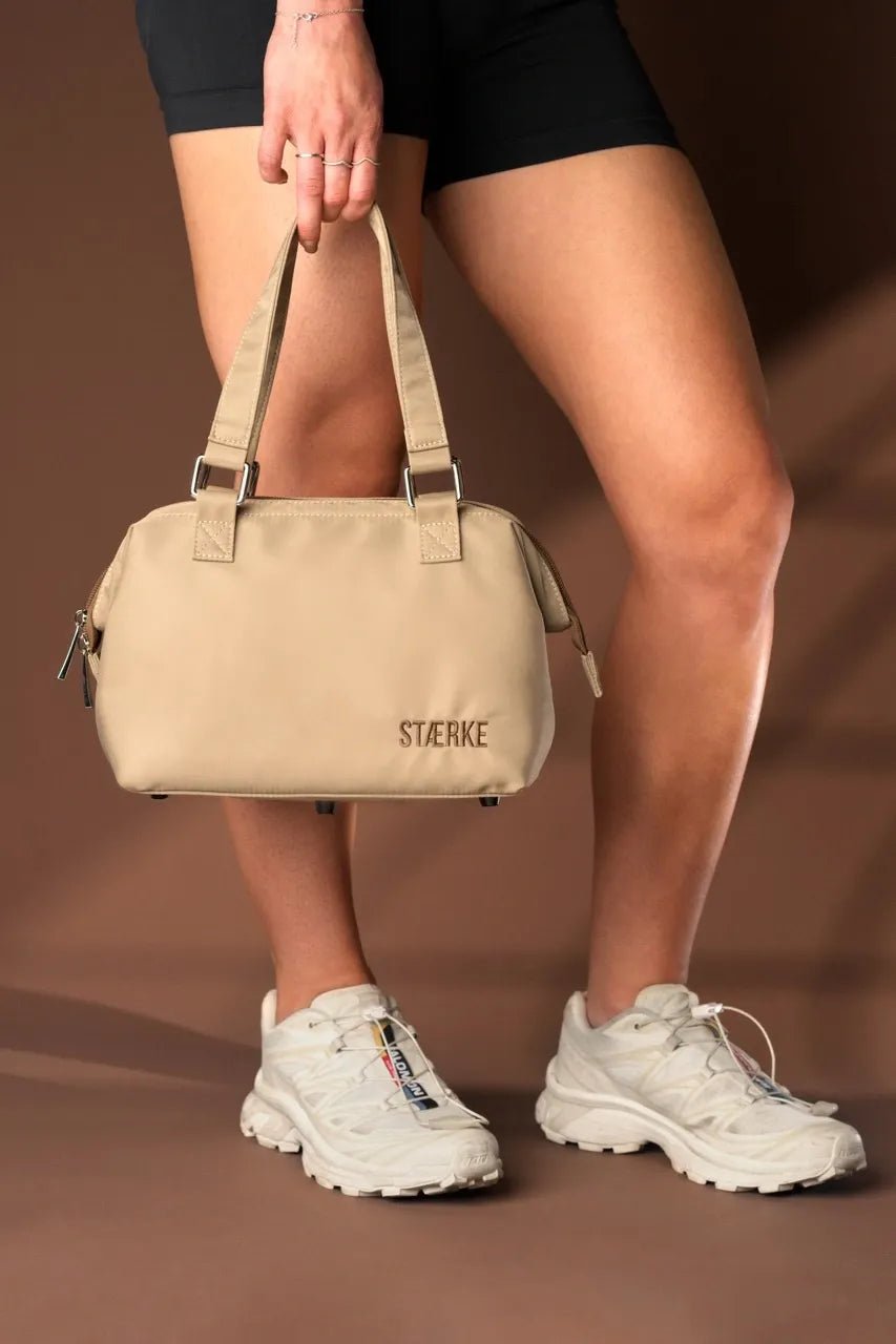 Large image of STÆRKE Mini In-Gym Bag showing its compact design, sturdy handles, and stylish black fabric for gym essentials.