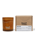 Mystice 250g scented soy candle by Russell + White, featuring a white glass jar and a lit flame, emitting a warm glow.