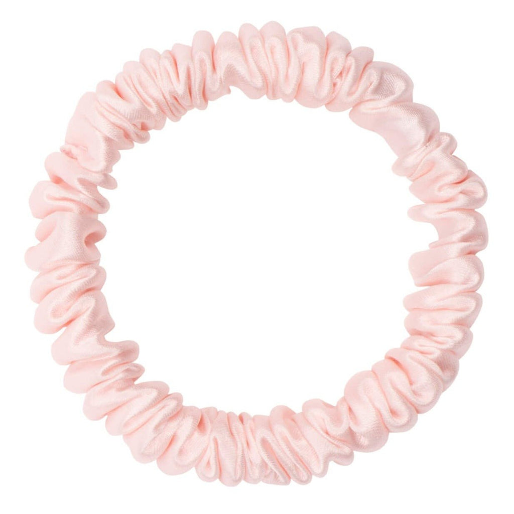 Pink silk skinny scrunchie by DREAMSILK, soft and smooth hair accessory with a sleek, slender design for gentle hold.