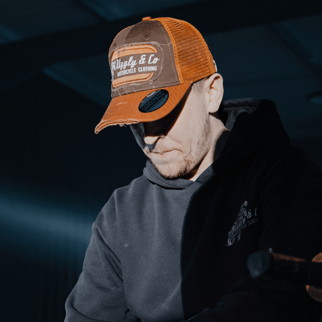 Rust flat track trucker hat by Uggly and Co featuring a classic trucker cap style with mesh back and distressed rust finish.