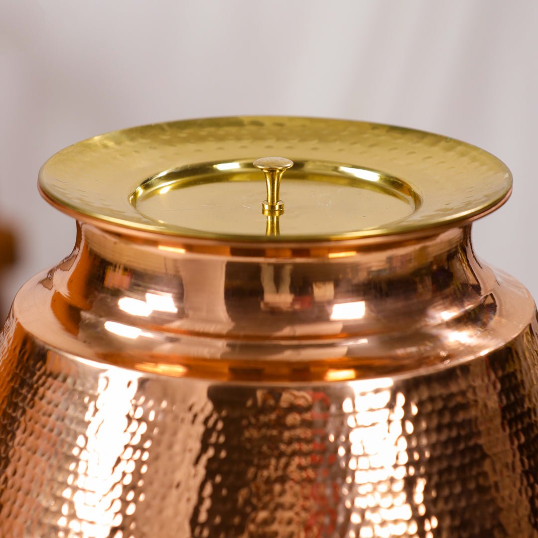 Handcrafted 8L pure copper water dispenser with hammered finish and tap, ideal for traditional Ayurvedic kitchen use.