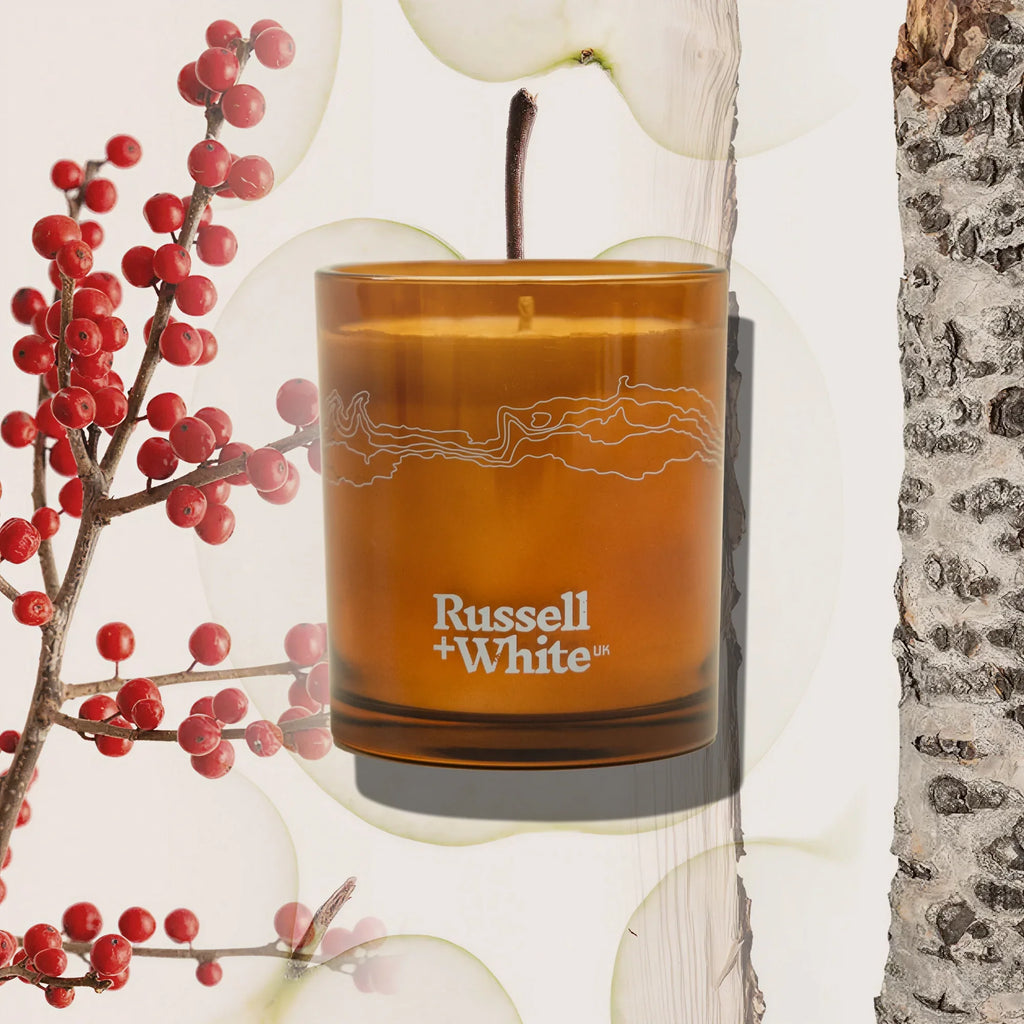 Russell + White Lingonberry scented soy candle in a glass jar with a wooden lid, showcasing a cozy, aromatic candle design.