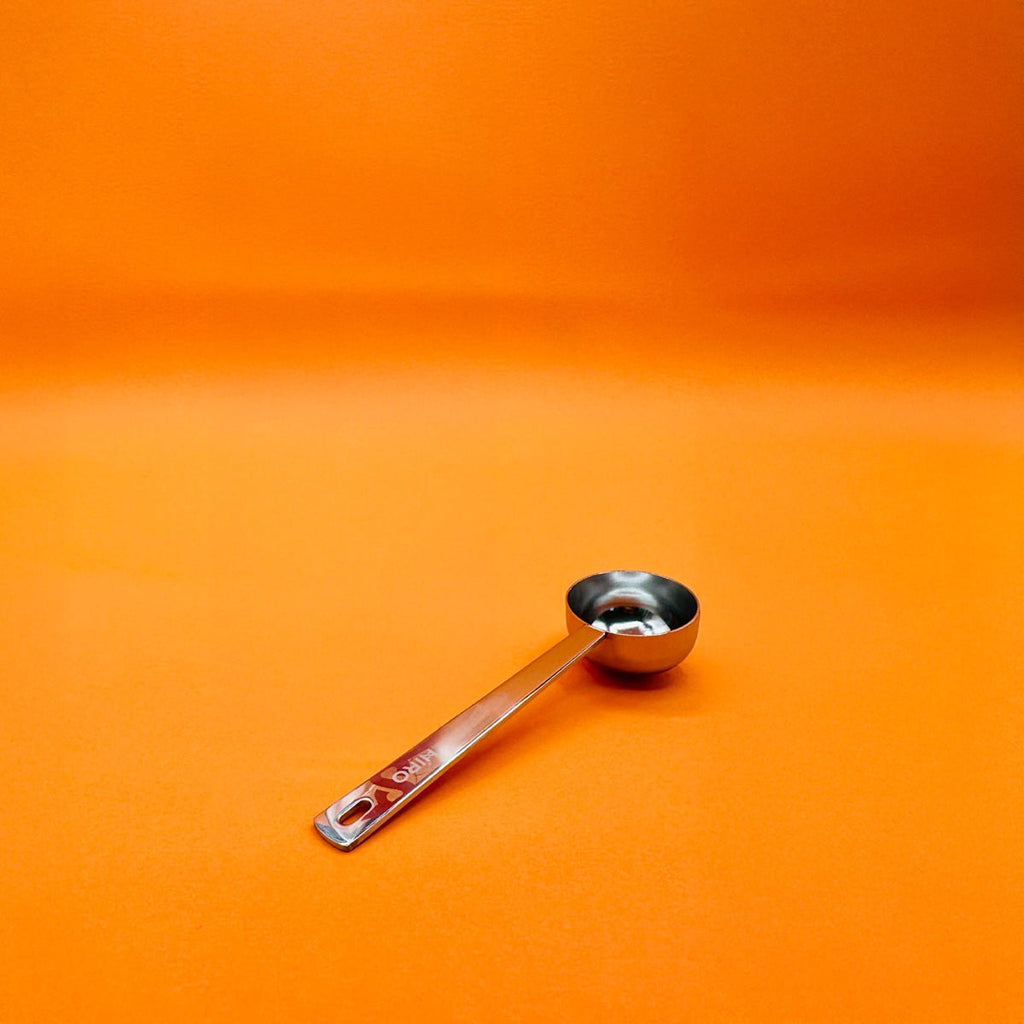 HIRO Superblend Scoop, orange-colored accessory tool for blending and scooping ingredients, with ergonomic handle and durable design.