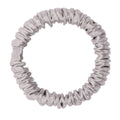 Silver silk skinny scrunchie from DREAMSILK, soft and shiny silk fabric with a slim design, shown on a white background.