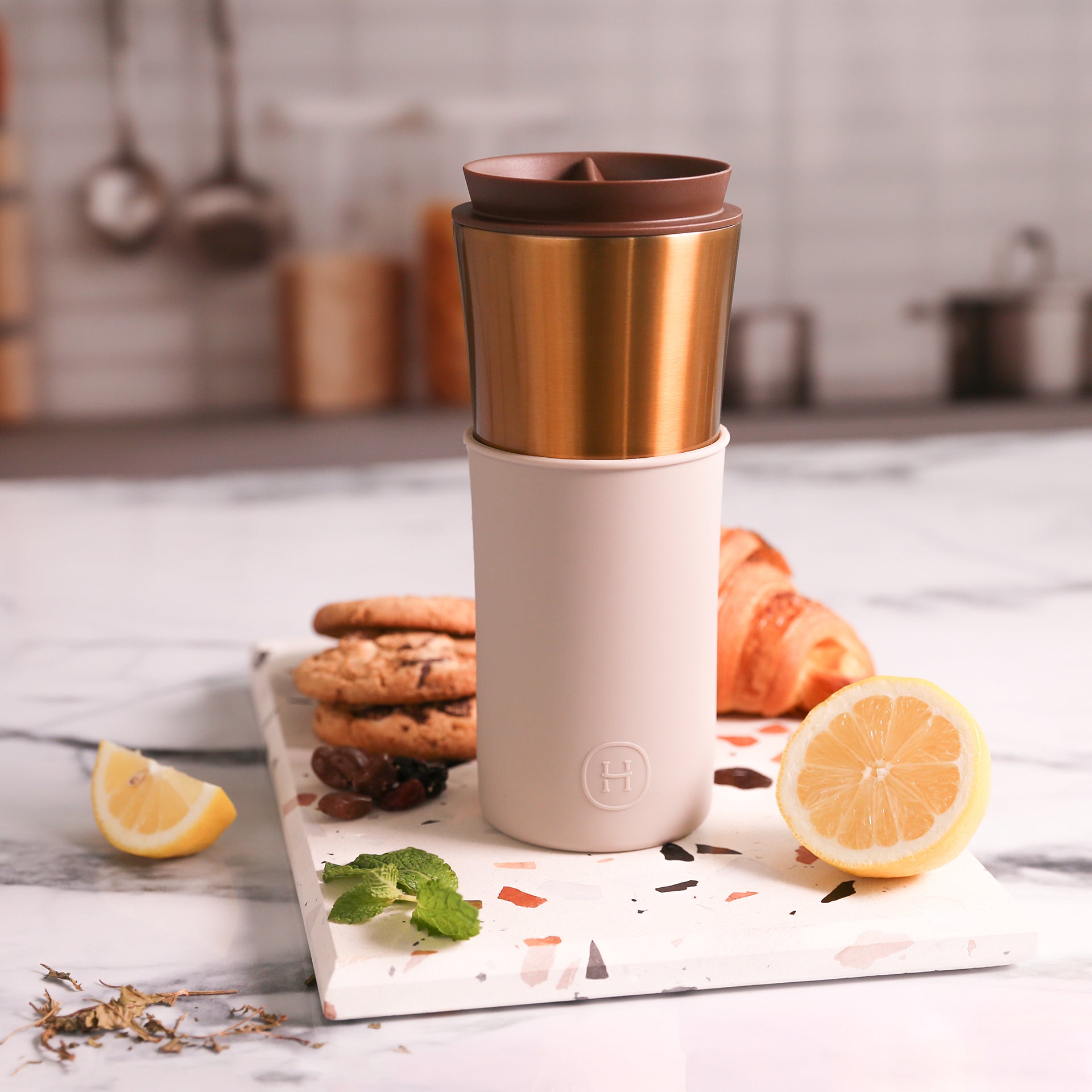 Bronze gold Eucalyptus travel mug by HYDY, 15 oz stainless steel mug with a sleek design and insulated lid for hot beverages.