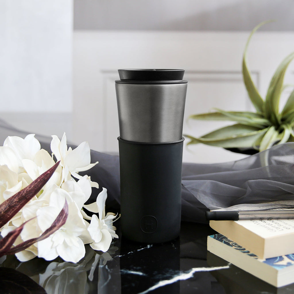 Titanium grey and ink black HYDY 15 oz travel mug with a sleek design, featuring a spill-proof lid and durable construction.