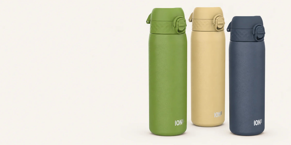 Ion8 khaki-green, desert and ash-navy bottles with matching flip-top lids on an ivory background.