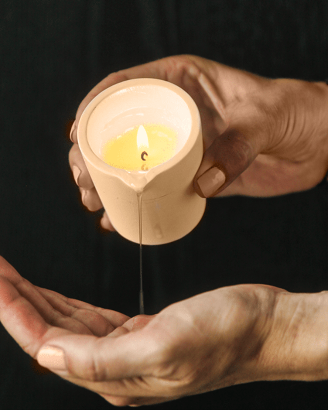 Scented massage candle by Musketeers with Mandarin and Sandalwood, shown melting and ready for massage use.