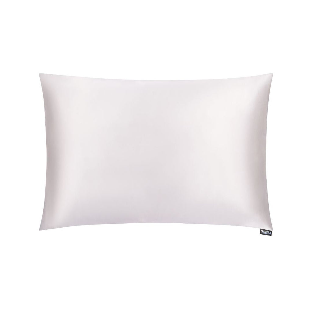 White silk pillowcase from DREAMSILK, standard size, smooth and luxurious fabric, displayed on a bed with soft lighting