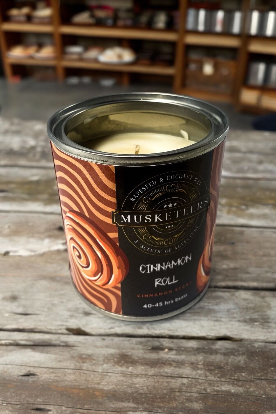 Musketeers cinnamon scented candle with warm spice aroma, housed in a glass jar, ideal for cozy home ambiance.