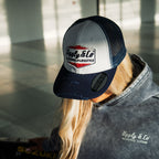 Navy blue and white diamond pattern Uggly and Co trucker cap with mesh back and curved brim, casual outdoor style.